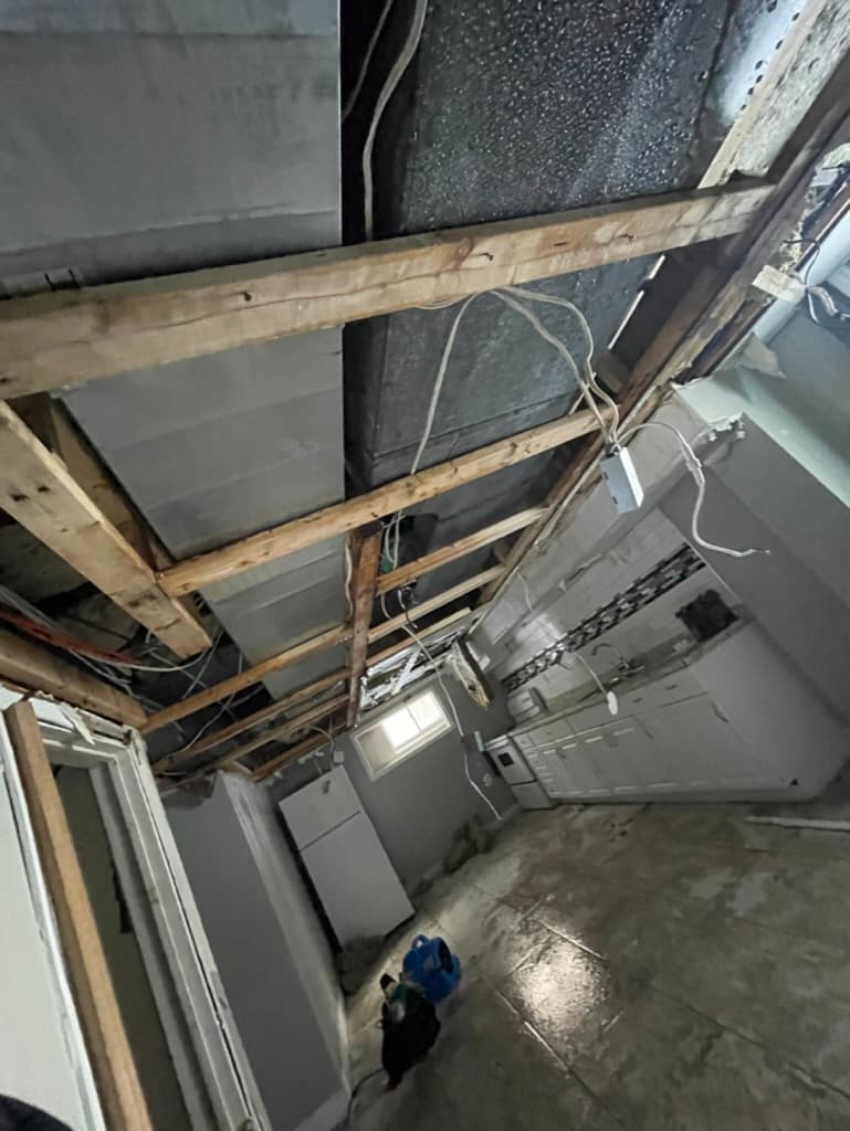 Water damage from frozen burst pipes in Niagara-on-the-Lake home, exposed ceiling and stripped interior