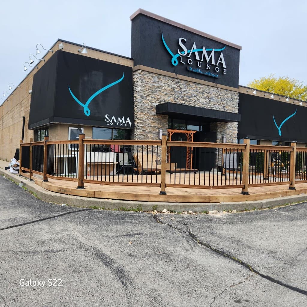Curved wooden deck with wood posts and black metal railings