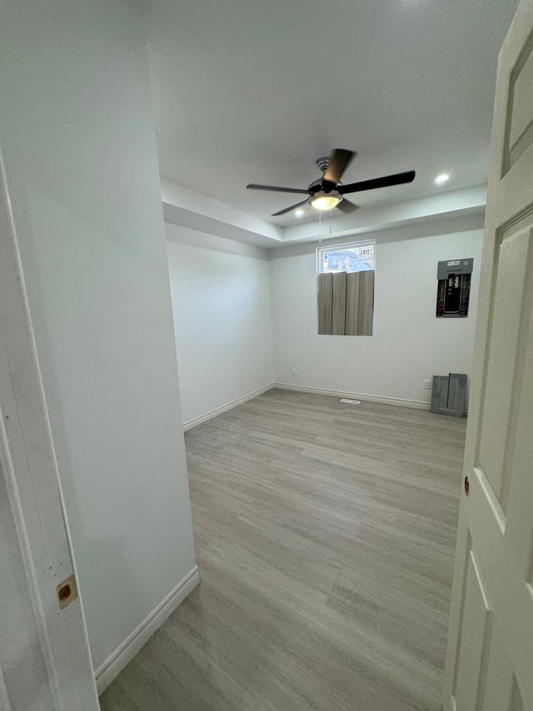 Completed drywall finishing with smooth walls, ceiling fan and recessed lights