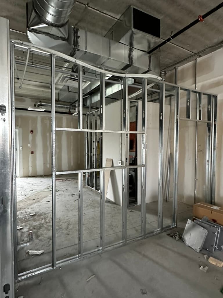 Metal stud framing for walls with HVAC ductwork and exposed ceiling