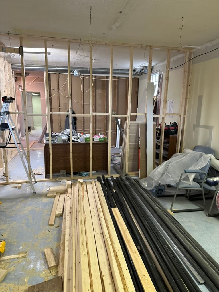 Wood stud wall framing with lumber and pipes during renovation