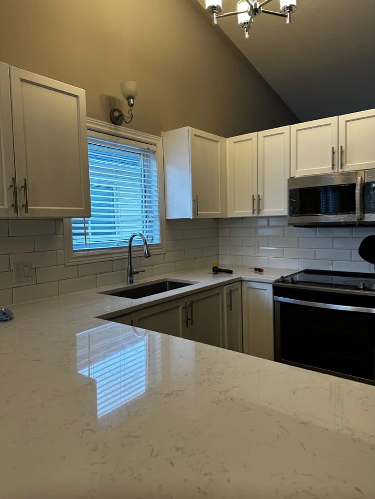 Modern renovated kitchen with light cabinetry, subway tile backsplash and stainless appliances