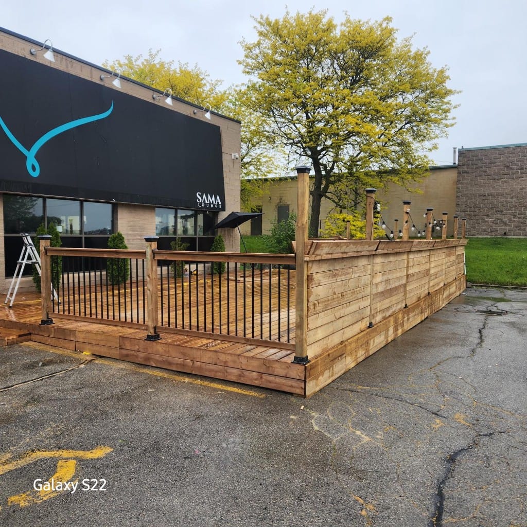 Completed commercial deck corner with black guard rails and privacy boards