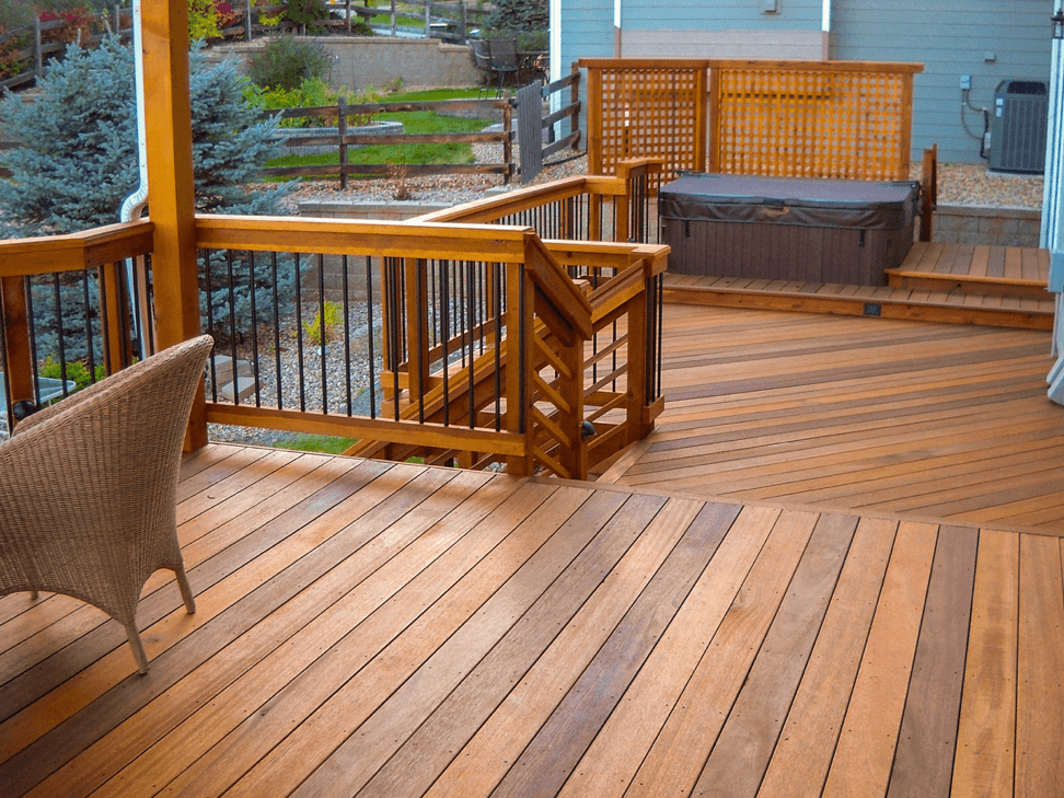 Residential deck with a hot tub, black guard rails and privacy screening