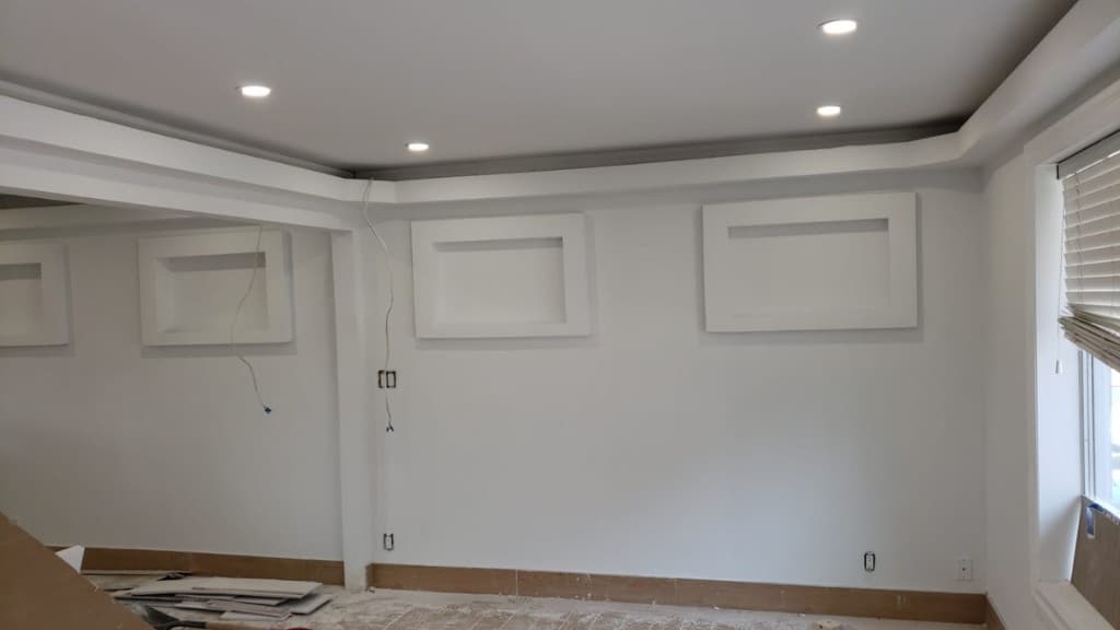 Finished drywall with decorative recessed panels, tray ceiling and recessed lighting