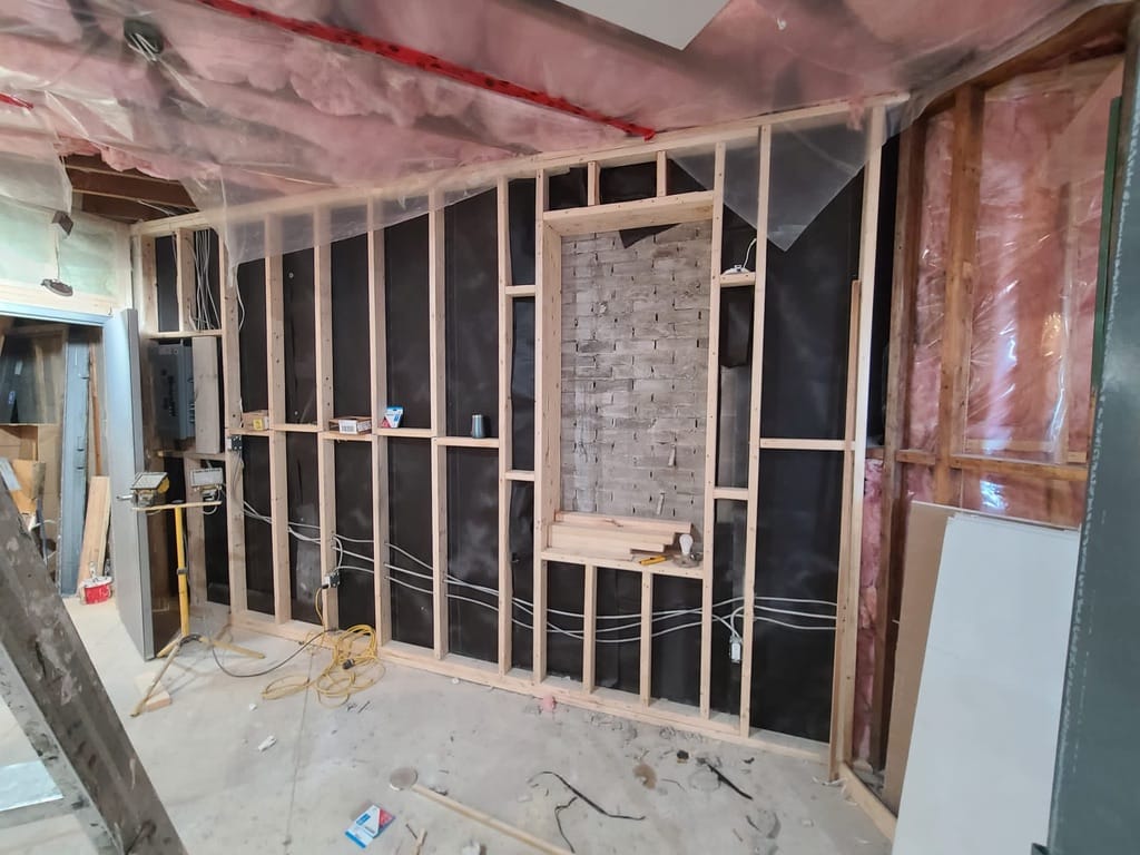 Custom wood wall framing with insulation and electrical rough-in